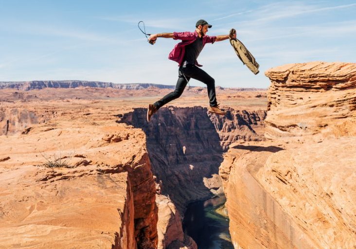 man jumping on rock formation